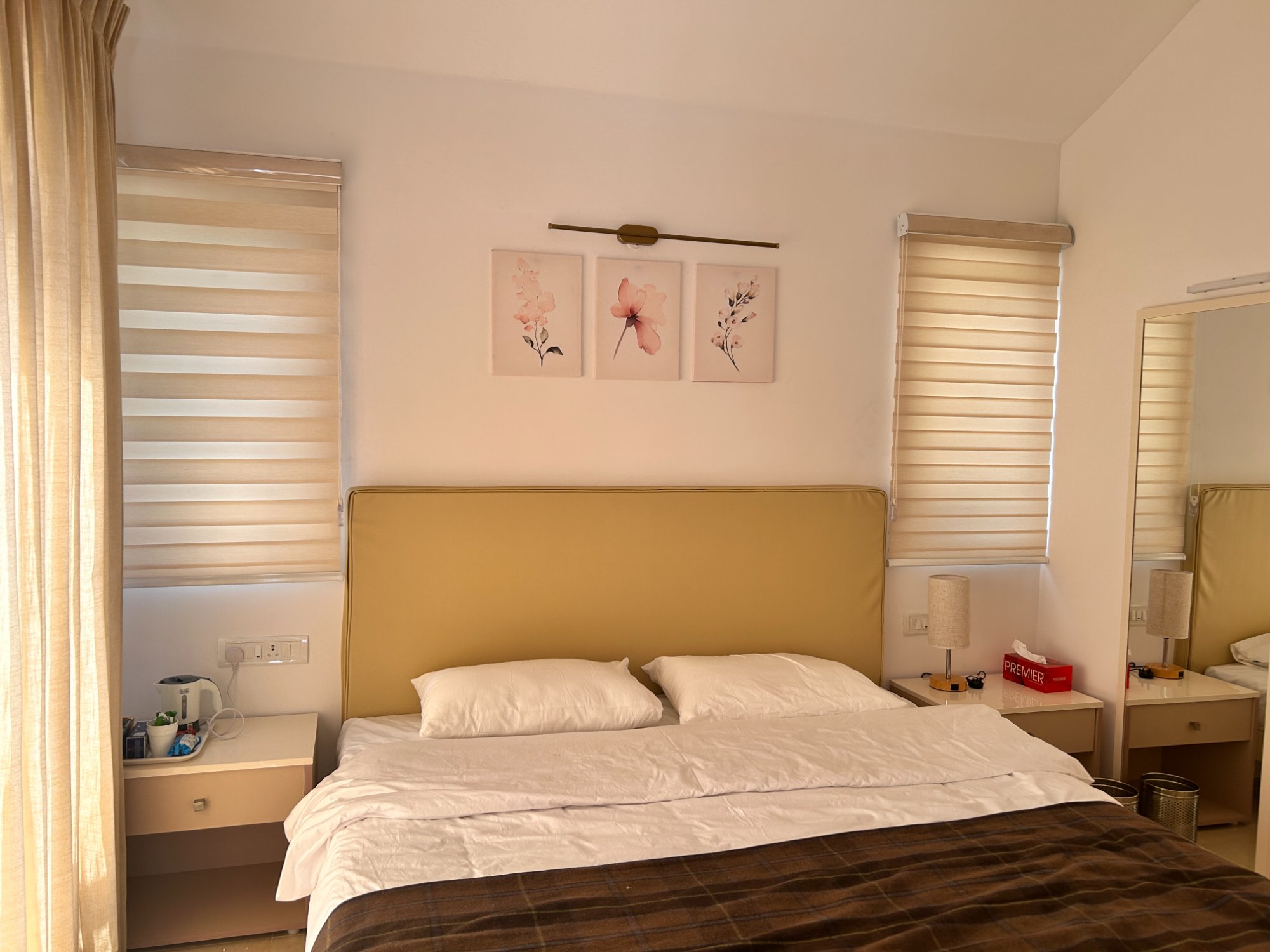 Bedroom with gold headboard and floral wall art