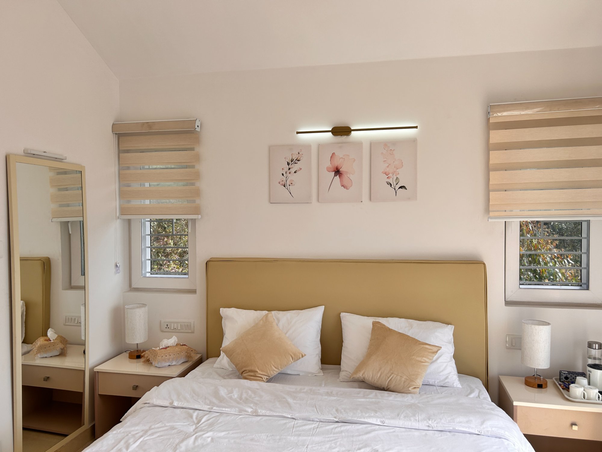 Bedroom with lit wall sconce and floral art