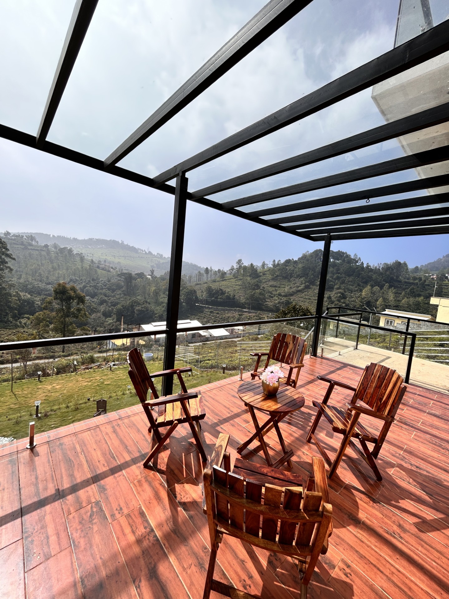 Deck seating area with wooden chairs and hill views