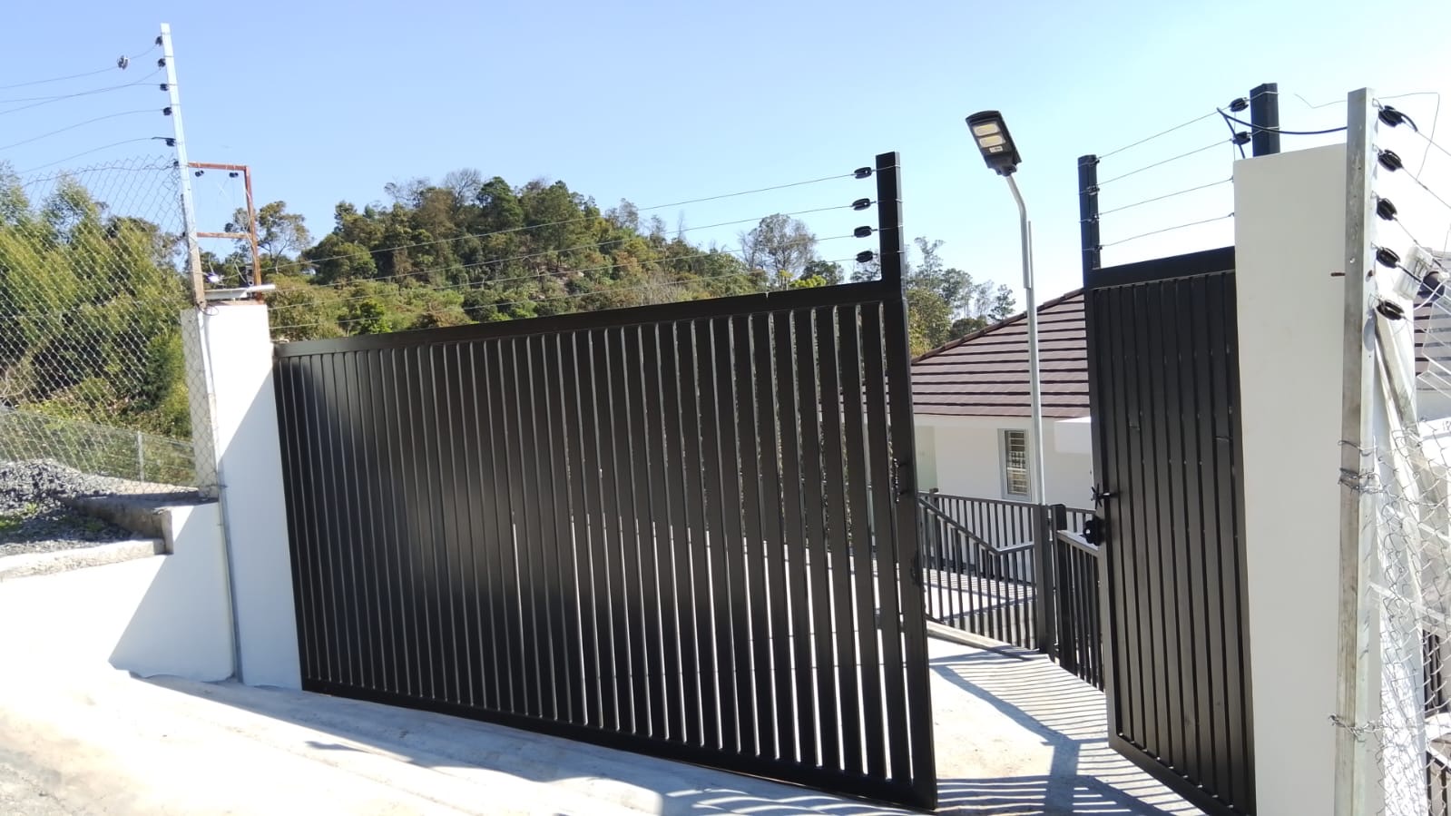 Secure black entrance gate to the villa